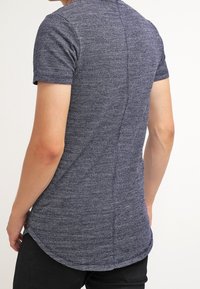 Navy blue short-sleeve t-shirt with a textured pattern and rounded hem, featuring a visible seam running down the back.
