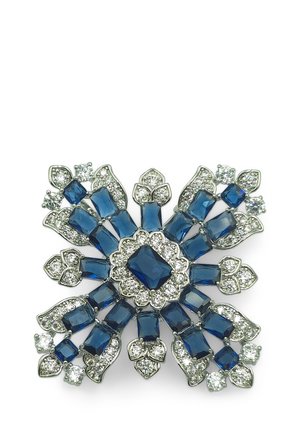 Spilla in gemma blu zaffiro con un intricato design floreale, accenti in metallo argentato e decorazioni in cristallo trasparente.