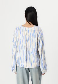 Langarmoberteil aus leichtem Stoff mit einem abstrakten Muster in Blau und Creme, lockerer Schnitt, Rundhalsausschnitt und abfallenden Schulternähten.
