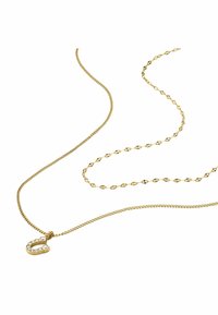 Collier en or avec un design de chaîne torsadée et un pendentif accentué présentant une lettre décorative ornée de pierres transparentes.