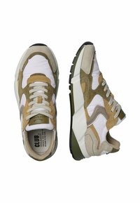 Baskets de sport avec une combinaison de tissu blanc et de suède beige, ornées d'accents texturés, de lacets ronds et d'une semelle épaisse.