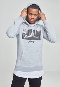 Gray hoodie made of fleece material, featuring a front graphic of hands in a praying position with "pray" text below. Kangaroo pocket included.