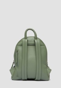 Zielony skórzany plecak z zaokrąglonym wierzchem, podwójnymi uchwytami oraz boczną kieszenią na zamek; fakturowana powierzchnia i przemyślany design.