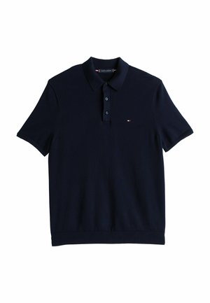 Polo de manga corta azul marino con tapeta de dos botones y pequeño logotipo rojo, blanco y azul en el lado izquierdo del pecho.