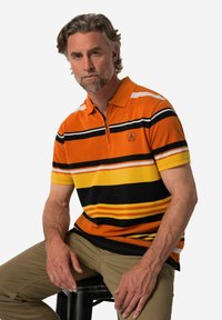 Pánská polokošile s krátkým rukávem v oranžové barvě s vodorovnými pruhy v žluté, černé a bílé. Má kontrastní límeček a logo na hrudi.