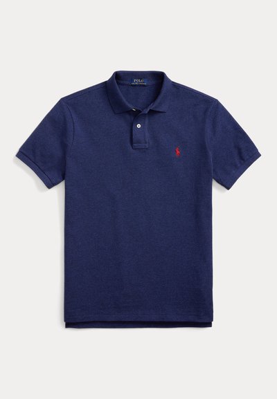 Marineblå polo skjorte laget av bomull, med en placket med to knapper, korte ermer og en rød brodert logo på venstre bryst.