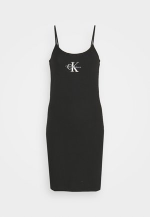 Robe noire ajustée avec de fines bretelles, faite en tissu doux. Présente un logo blanc "Calvin Klein Jeans" sur le devant.