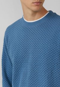 Niebieska dzianinowa bluza z fakturowanym wzorem tkanym, okrągłym dekoltem z kontrastującymi żebrowanymi akcentami i miękką tkaniną.