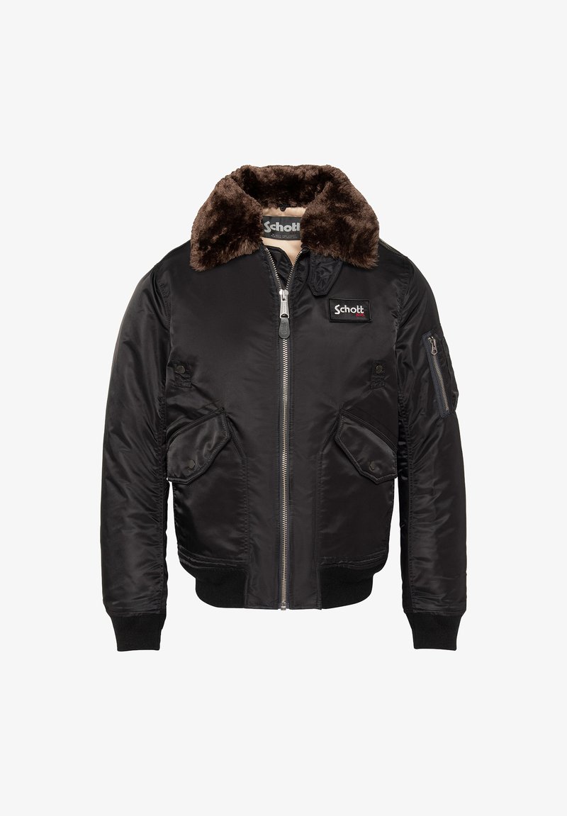 Veste bomber noire avec col en fourrure marron, fermeture éclair frontale, deux poches à rabat boutonnées, poche zippée sur la manche et patch avec logo Schott sur la poitrine.