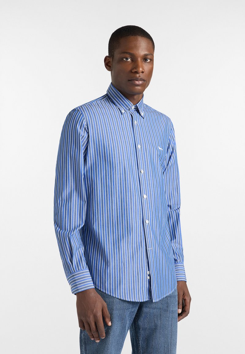 Chemise à rayures bleues et blanches avec col boutonné, manches longues et coupe ajustée. Présente un petit logo de marque sur la poitrine.