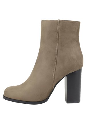 Stivale alla caviglia in suede beige con punta arrotondata, dettaglio di cuciture laterali e tacco spesso nero a blocco. Texture liscia, altezza a metà polpaccio.