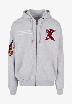 Hallux hallitav halli kapuutsiga sviiter, mis on valmistatud pehmest kangast. Omab tikitud tähti "K" ja "ANI," vasakul varrukal on graafilised aktsendid ning trükitud tekst.