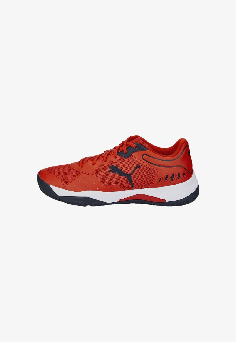 Zapatilla deportiva roja hecha de malla y materiales sintéticos, con un logo negro, panel lateral texturizado y una media suela blanca con suela de agarre.