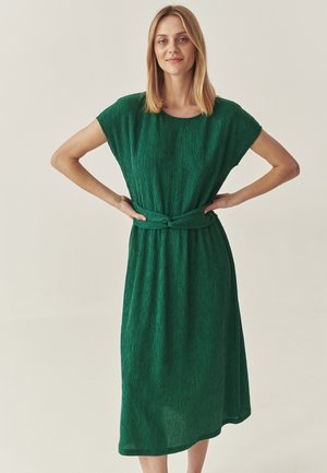 Rochie midi verde, texturată, cu mâneci scurte, o croială lejeră și un detaliu de talie legat. Design simplu cu o siluetă fluidă.