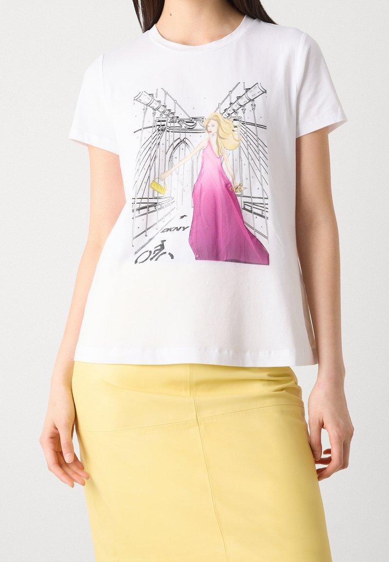 T-shirt blanc avec illustration d’une femme en longue robe rose tenant une pochette jaune sur un pont avec câbles et marquages pour piste cyclable.