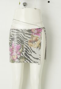 Metaalgaas mini-rok met een zebrapatroon en roze en gele bloemenaccenten. Inclusief een zilveren kettingdetail bij de taille.