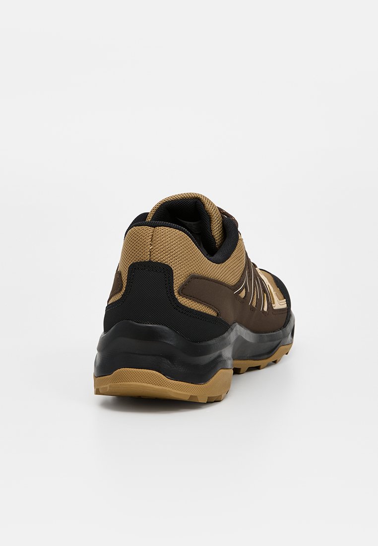 Zapatilla deportiva marrón y negra con parte superior texturizada, talón reforzado y suela de goma. Cuenta con paneles de malla y un collar acolchado para mayor comodidad.