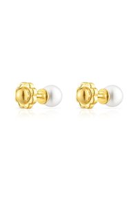 Pendientes de perno en tono dorado con acentos de diseño floral, con un suave centro de perla blanca. Forma redonda con un acabado pulido.