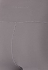 Grå sportshorts gjorda av mjukt, stretchigt material med en söm i mitten och "ENDURANCE" präglat på midjebandet.
