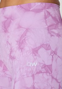 Leggings violets avec un motif marbré, une taille côtelée et le logo "ICIW" en blanc sur le côté inférieur. Texture lisse.