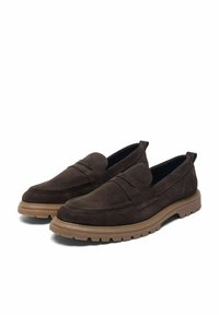 Braune Wildleder Slipper mit einem unkomplizierten Design, das über genähte Details und Gummisohlen für besseren Grip verfügt. Glatte, strukturierte Oberfläche.