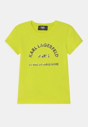 T-shirt pour enfants à manches courtes de couleur jaune vif avec col rond, texte argenté indiquant "KARL LAGERFELD PARIS 21 RUE ST-GUILLAUME" sur le devant.