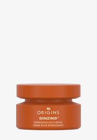 Oranje pot met een matte afwerking, voorzien van een vlak deksel en witte tekst. Etiket zegt "Origins Ginzing Energizing Rich Cream."
