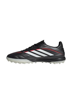 Scarpa da calcio nera con strisce Adidas bianche, linee accentuate rosse e suola chiodata grigio chiaro, mostrata in profilo laterale.