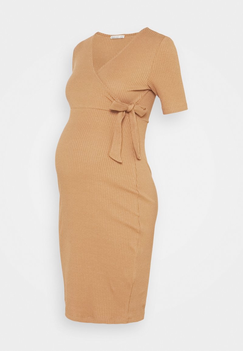 Ljusbrun ribbad gravidklänning med omslagdesign, korta ärmar och knytning i midjan. Tyget har en mjuk struktur och elastisk känsla.