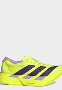 Scarpa da corsa giallo brillante con strisce nere, accenti viola e suola spessa etichettata Lightstrike Pro, vista laterale su sfondo bianco.