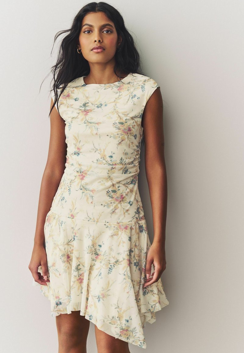 Ein blütenmusterndes Kleid mit einem weichen cremefarbenen Grundton, tailliertem Oberteil, kurzen Ärmeln und einem ausgestellten, asymmetrischen Saum. Strukturierter Stoff mit leichtem Raffung.