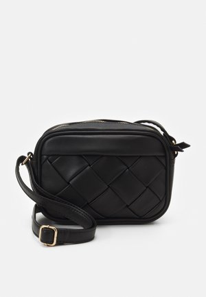 Sort crossbody taske med vævet mønster foran, guldfarvet spænde på justerbar rem og lynlåslukning øverst.