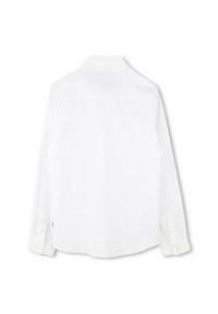 Camicia bianca a maniche lunghe con colletto a polo, con un'unica ymmerdina sul retro e bottoni bianchi sui polsini. Tessuto di superficie liscia.