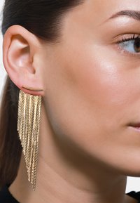 Gouden drop oorbellen met een reeks van watervalletjes van gestructureerde kettingen. Eenvoudig gebogen staafstudcomponent verbindt met de basis van de oorbel.