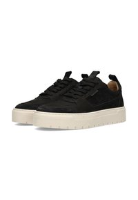 Sneaker nere in suede con una spessa suola in gomma color crema, caratterizzate da dettagli testurizzati e lacci neri, progettate con una forma minimalista.