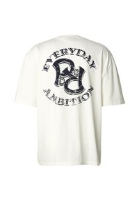 Vit t-shirt i bomull med ett stort svart tryck på ryggen, med texten "EVERYDAY AMBITION" i en sliten stil. Kortärmad, lös passform.