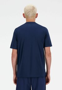 Navy blue athletic t-shirt with short sleeves, smooth texture, and a crew neckline. Back view shows a straight cut and no logos or patterns.