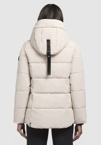 Puffermantel in hellbeige mit gestepptem Design, auffälliger Kapuze und einem Logoetikett auf der Rückseite. Verfügt über seitliche Reißverschlusstaschen und eine lockere Passform.