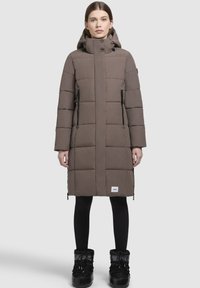 Puhasti kaput, sivo-smeđi, do koljena, u�šiveni dizajn, visoki ovratnik s podešavanjima, dva bočna džepa sa zatvaračem, nosi se s crnim tajicama i čizmama.