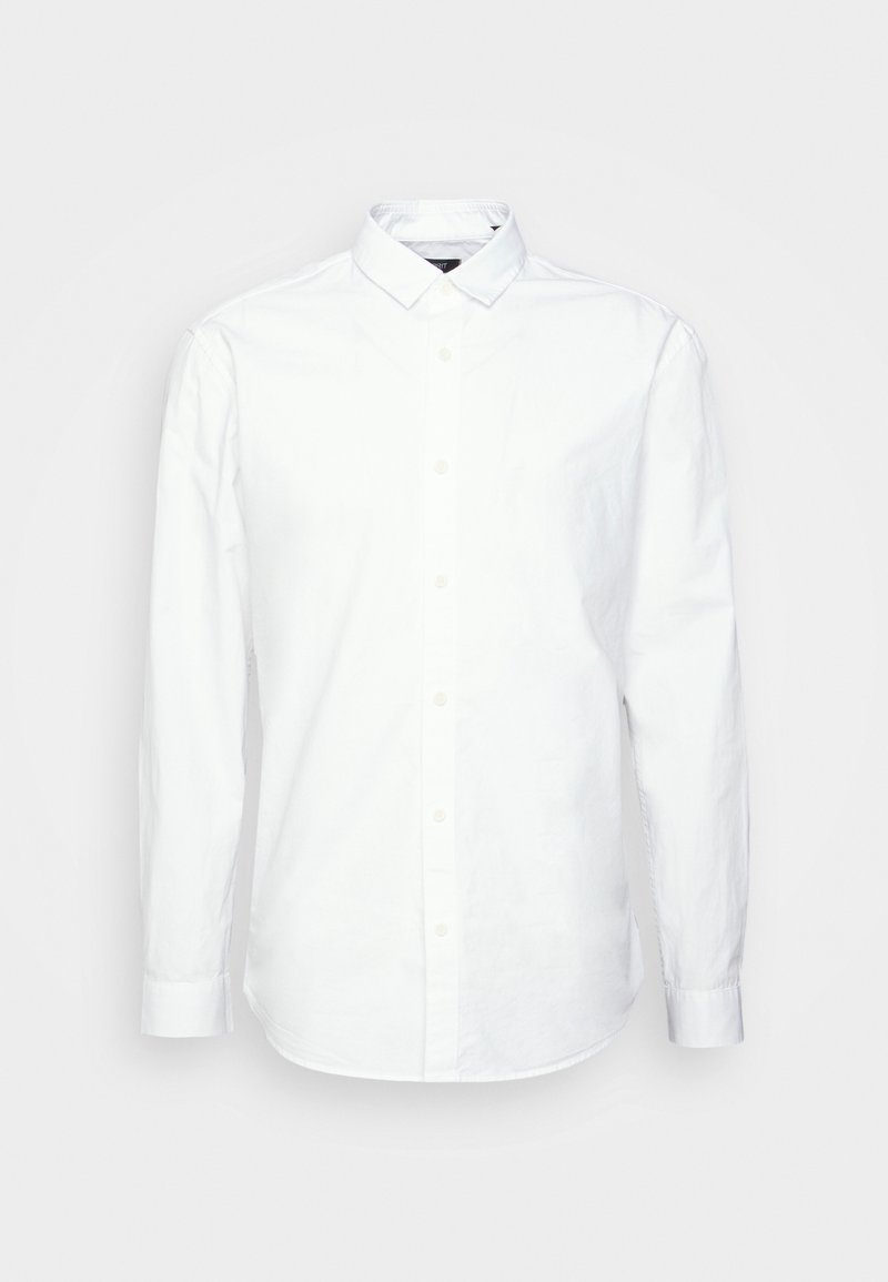 Chemise blanche à manches longues avec boutons et col pointu, affichée sur un fond clair uni.
