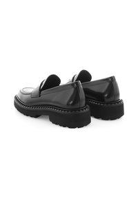Schwarze Lackleder-Loafers mit einer massiven Gummisohle, die ein strukturiertes Design und eine elegante Silhouette aufweisen, um eine moderne Ästhetik zu bieten.