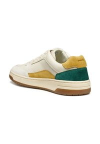Zapatillas de hombre con parte superior de cuero color crema, acentos de gamuza en amarillo y verde, suela de goma, cierre de cordones y marca Geox en el talón.