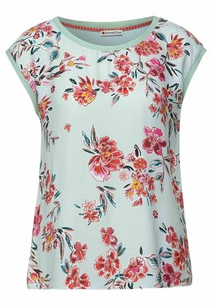 Lyseblå kortærmet skjorte med pink, rød og orange blomster mønster og grøn kant omkring halsudskæring og ærmer.