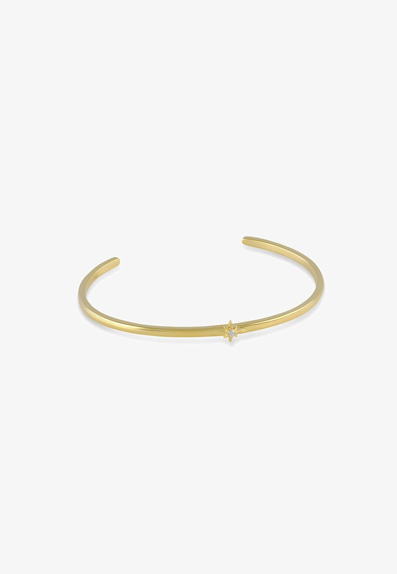 Bracelet manchette fin en or avec un petit charme en forme d'étoile, orné d'une pierre précieuse claire au centre, design ouvert sur fond blanc.