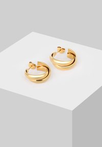 Goldene Creolen mit einer glatten, glänzenden Oberfläche. Mit einem gedrehten Design und sicherem Steckverschluss.