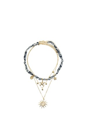 Layered gold-tone necklaces with a black and white patterned fabric cord and sun, starfish, and shell-shaped charms.