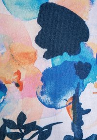 Textil con un patrón abstracto multicolor que presenta salpicaduras en navy, azul, naranja y rosa. Incluye contornos de hojas en verde oscuro.