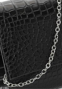 Sac à main en similicuir noir à texture embossée façon croco, doté d'une bandoulière en chaîne argentée et d'une forme rectangulaire élégante.