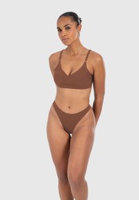 Bruine bikini set met een V-hals bralette en een hoog uitgesneden stringonderdeel. Glad stof met verstelbare banden, ontworpen voor comfort en pasvorm.