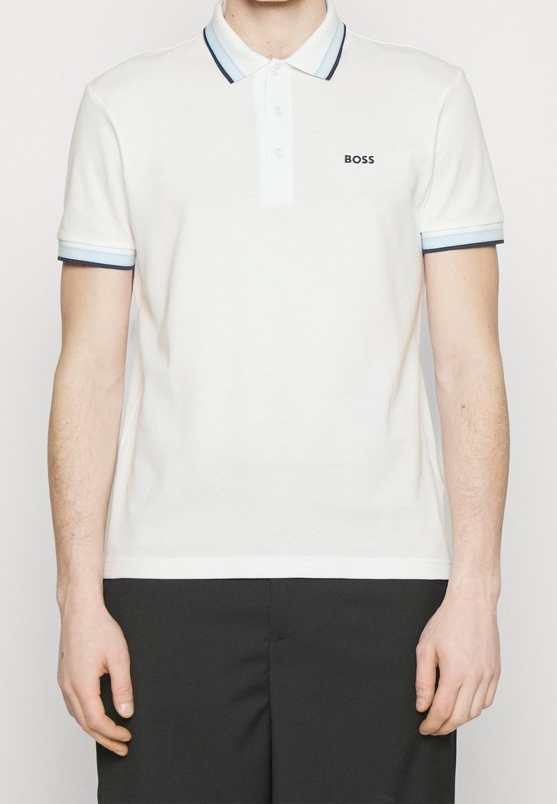 Bílé polo tričko vyrobené z bavlny, s dvoubarevným zapínáním na knoflíky, kontrastním modrým a černým žebrovaným límcem a manžetami, s logem "BOSS".